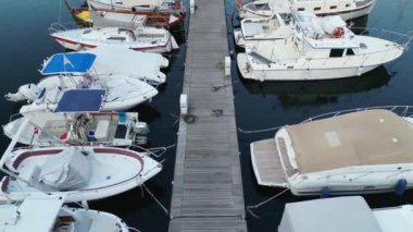 Tekneler ve yatlarla deniz koyunun drone görüntüsü.