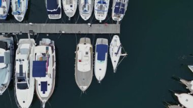 Tekneler ve yatlarla deniz koyunun drone görüntüsü.