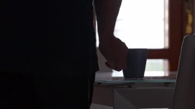 Adam sabah kahvesini balkonda içiyor.