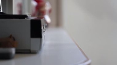 Adam bir video oynatıcıdan VHS kaset alıyor.