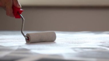 Adam silindirle resim yapıyor.