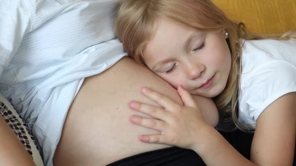 Klein Meisje Zet Haar Oor Naar Haar Zwangere Moeders Buik — Stockvideo
