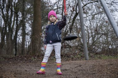 Çocuk parkta salıncakta sallanıyor..