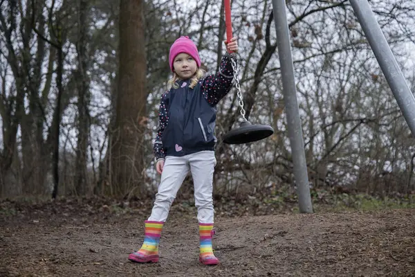 Çocuk parkta salıncakta sallanıyor..