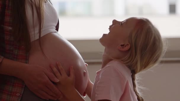幼稚園の少女は妊娠した母親を抱きしめる — ストック動画