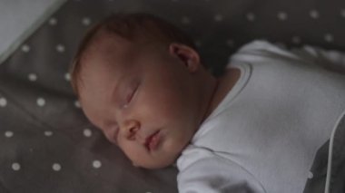 Yeni doğmuş bebek yatakta uyuyor.