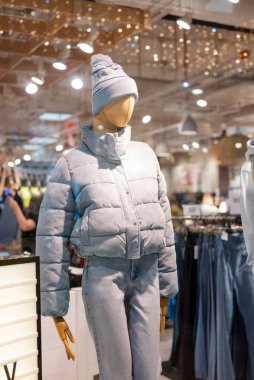 Mankenler bir mağazada sergileniyor ve alışveriş merkezinde giysileri var.