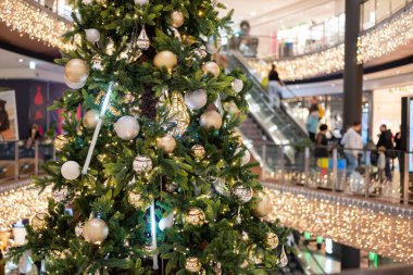 Noel için alışveriş merkezindeki Noel ağacında çelenk ve bulanık bokeh arka planda süslemeler.