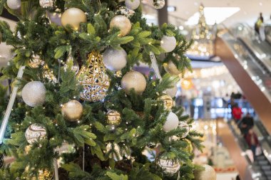 Noel için alışveriş merkezindeki Noel ağacında çelenk ve bulanık bokeh arka planda süslemeler.