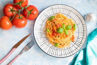 Italian pasta in a restaurant with tomato sauce and basil