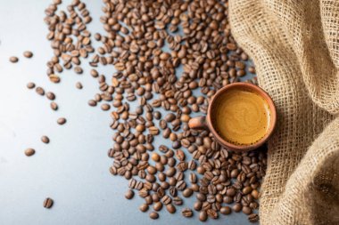 hot delicious aromatic coffee black espresso in a white cup on a background of coffee beans