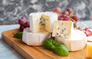 delicious blue brie blue cheese with grapes  on a wooden board