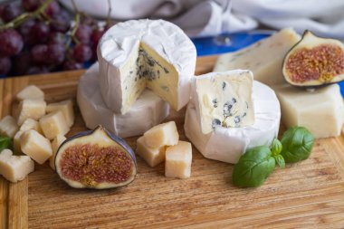 delicious blue brie blue cheese with grapes  on a wooden board