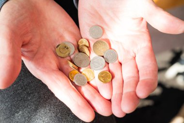 Elinde para tutan emekli kadın zloti emekli maaşı ve ödeme için bozuk para ödüyor.