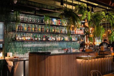 28 Mart 2025, Gdansk Polonya, bir restoranda bar tezgahı ve raflar alkolle dolu.