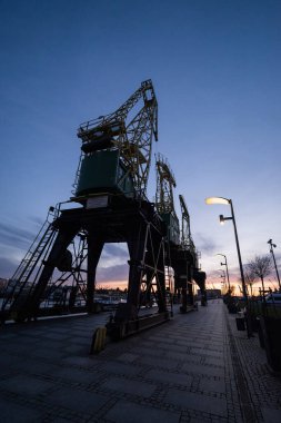 Szczecin Polonya, 5 Nisan 2025, şafak vakti vinç manzaralı şehir merkezindeki tersanede turistik bir yer.