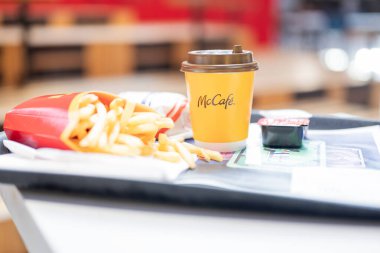 Szczecin Polonya - 5 Nisan 2025, McDonalds 'da bir tepside hazır yemek, kahve, patates kızartması ve bir restoranda sos.