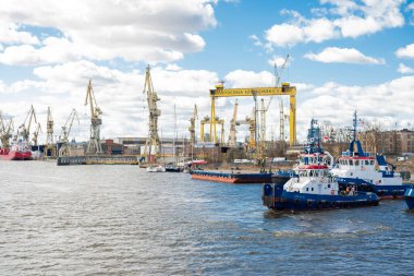 Szczecin Polonya - 5 Nisan 2025, nehir kıyısında vinç ve gemilerle deniz kargo limanı