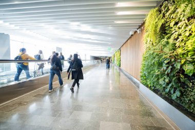 27 Nisan 2025 Stockholm İsveç, Arlanda Havalimanı terminalleri arasında yürüyen merdiven ve yolcular arasında geçiş.