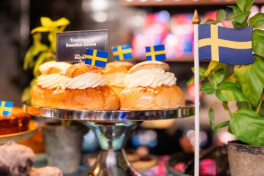 İsveç usulü lezzetli hamur işleri Stockholm 'de tatlı yiyecekler kafede bayraklar ve semla çörekleri sergileniyor. 