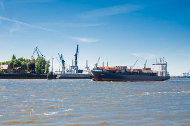 Hamburg Almanya, 12 Mayıs 2025, Elbe Nehri 'nin şehir merkezindeki dolgu limanında yüzen bir konteynır dolusu deniz kargosuyla.