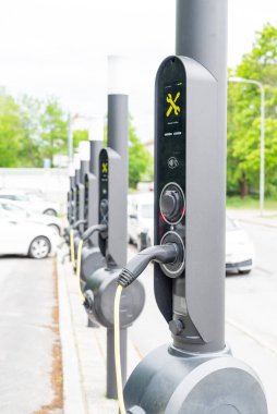 Stockholm İsveç 7 Temmuz 2025, EV şarj cihazı gündüz vakti bir arabaya bağlı. Sürdürülebilir hareketlilik ve yeşil teknoloji.