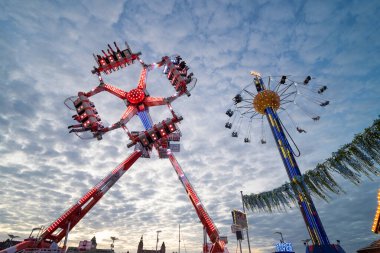 Szczecin Polonya, 8 Temmuz 2025, Günbatımında döngü dövüşçüsüyle Holiday Lunaparkı manzarası