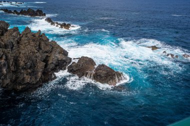 Porto Moniz, volkanik sahilde kayalar ve dalgalar - Madeira Adası, Portekiz 'in güzel manzarası