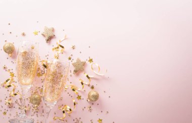 Yeni yılın geçmiş kutlamaları kutlu olsun. Şampanya kadehi, altın kurdele, yıldızlar ve pastel arka planda noel balosu..