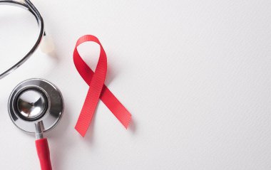 Yakın plan kırmızı kurdele HIV, beyaz arka planda AIDS Günü Farkındalık Kurdelesi. Sağlık ve Tıp Konsepti.