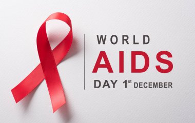 Yakın plan kırmızı kurdele HIV, dünya AIDS Günü Farkındalık Kurdelesi ve beyaz arka plan metni. Sağlık ve Tıp Konsepti.