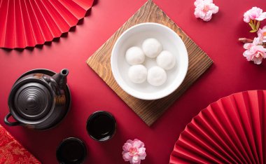 Tang Yuan (tatlı köfte topları), geleneksel bir sonbahar mutfağı, Dongzhi (kış gündönümü) ve erik çiçeği ve kırmızı zemin üzerinde çay bulunan Çin yeni yılı..