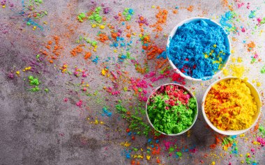 Mutlu Holi dekorasyonu, Hint festivali. Koyu taştan arka planda renkli holi tozu manzarası..