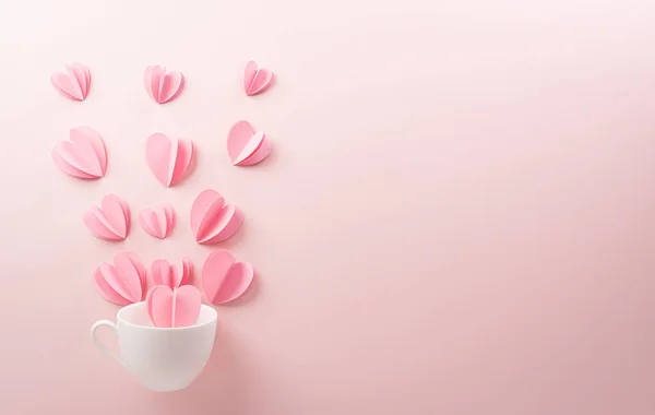 Pink paper hearts splash out from white coffee cup on pastel pink paper background. Love and Valentine\'s day concept.