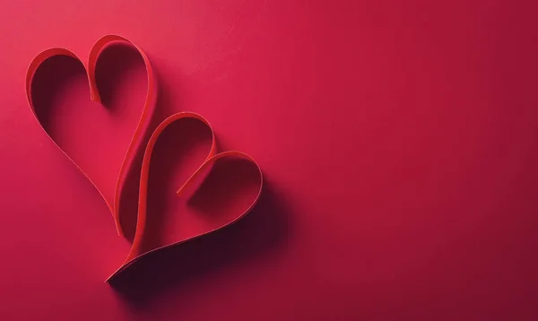 Love and Valentine\'s day concept made from paper hearts on dark red background.
