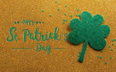 Happy St Patrick's Day decoration concept made from shamrocks ( clover leaf) on golden background.