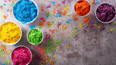 Mutlu Holi dekorasyonu, Hint festivali. Koyu taştan arka planda renkli holi tozu manzarası..