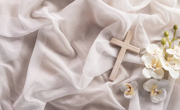 Good Friday and Holy week concept - A religious cross and flower on white fabric background.
