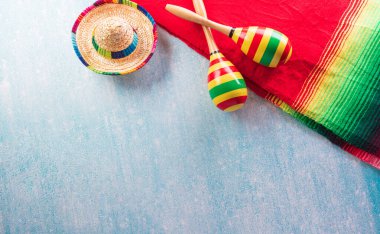Marakas, Meksika battaniye şeritleri ya da panço serape, kaktüs ve sarı arka planda şapkadan yapılmış Cinco de Mayo tatil arka planı..