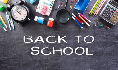 Eğitim ya da okula dönüş konsepti. Renkli okul malzemelerinin kitaplarla, renkli kalemlerle, hesap makinesiyle, kalemle, kesiciyle ve arka plandaki kliplerle en iyi görünümü.