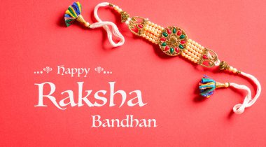 Raksha Bandhan, kırmızı arka planda güzel Rakhi olan Hint festivali. Geleneksel Hint bilekliği kız kardeşler ve erkek kardeşler arasındaki aşkın sembolüdür..