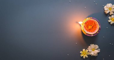 Happy Diwali - Clay Diya lamps lit during Diwali, Hindu festival of lights celebration. Colorful traditional oil lamp diya on blue background