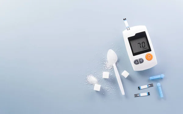 世界糖尿病デーコンセプト14 11月 パステルブルーの背景に血糖計セットと砂糖のトップビュー ロイヤリティフリーのストック写真