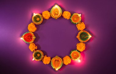 Mutlu Diwaliler - Dipavali sırasında Clay Diya lambaları yandı, Hindu ışık festivali kutlaması. Mor arka planda renkli geleneksel gaz lambası diya