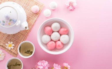 Tang Yuan (tatlı köfte topları), geleneksel bir sonbahar ortası mutfağı, Dongzhi (kış gündönümü) ve erik çiçeği ve pastel arka planda çay bulunan Çin yeni yılı..