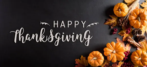 Koyu ahşap arka planda kuru yapraklar ve balkabağından sonbahar dekorasyonu. Şükran Günü konsepti.