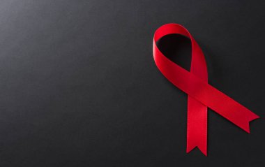 Yakın plan kırmızı kurdele HIV, dünya AIDS Günü farkındalığı kurdelesi. Sağlık ve Tıp Konsepti.