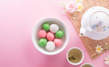 Tang Yuan (tatlı köfte topları), geleneksel bir sonbahar ortası mutfağı, Dongzhi (kış gündönümü) ve erik çiçeği ve pastel arka planda çay bulunan Çin yeni yılı..