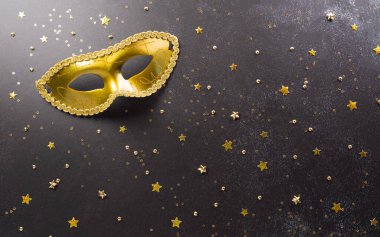 Happy Purim carnival decoration concept made from golden mask star and glitter on dark background. (Happy Purim in Hebrew, jewish holiday celebrate)