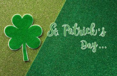 Happy St Patrick's Day decoration concept made from shamrocks ( clover leaf) and the text on green background.